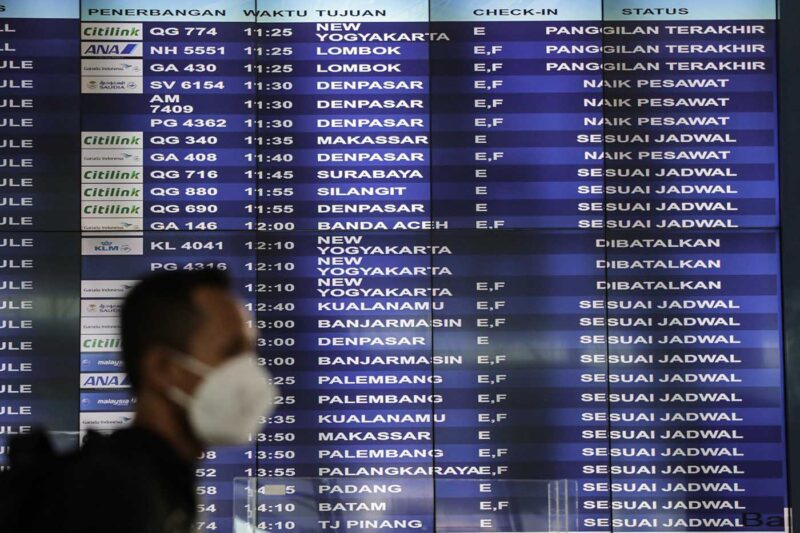 Calon penumpang pesawat berjalan di depan papan jadwal penerbangan domestik di Terminal 3 Bandara Soekarno Hatta, Tangerang, Banten (Foto: ANTARA FOTO)
