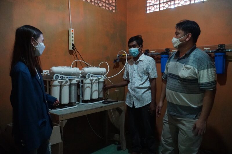 Talisha Joelyn (mahasiswi semester 4) bersama Ir. Surya Hermawan (dosen UKP-masker putih) menerangkan cara kerja alat pada pemilik rumah pak Amin Tohari (tengah)