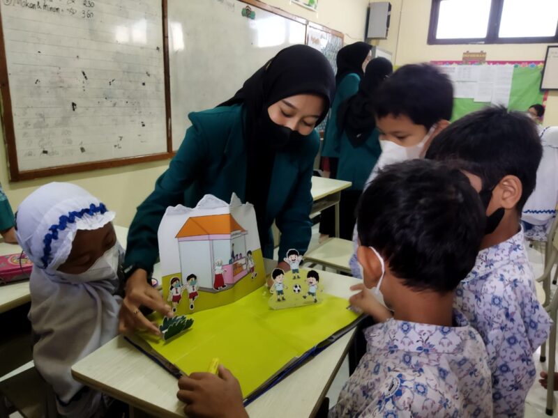 Mahasiswa UHW Perbanas saat mengenalkan dan mengajarkan penggunaan Pop Up Book kepada siswa SD Al Falah Darussalam (Foto: Christiana Beatrix)