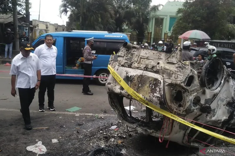 (Menko PMK) Muhadjir Efendi (kiri) pada saat melihat bekas mobil yang terbakar di depan Stadion Kanjuruhan, Kabupaten Malang, Jawa Timur, Minggu (2/10/2022). (Foto: ANTARA/Vicki Febrianto)