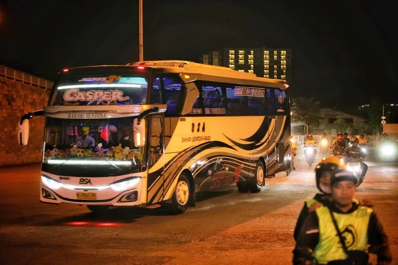 Bus Persija dikawal puluhan suporter Persebaya, Bonek, saat menuju ke Stadion Gelora Joko Samudro, Gresik, Selasa (4/4/2023). (Foto: ANTARA/Rizal Hanafi)