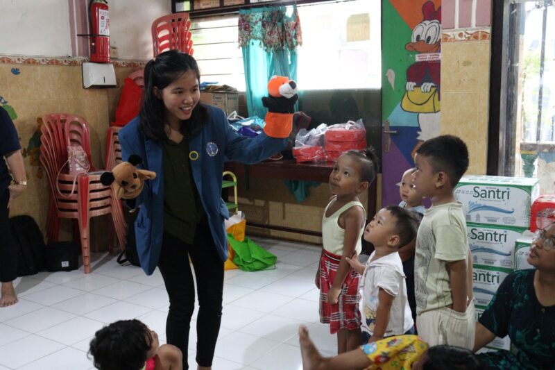 Seorang mahasiswi PCU sedang mendongeng tentang literasi keuangan